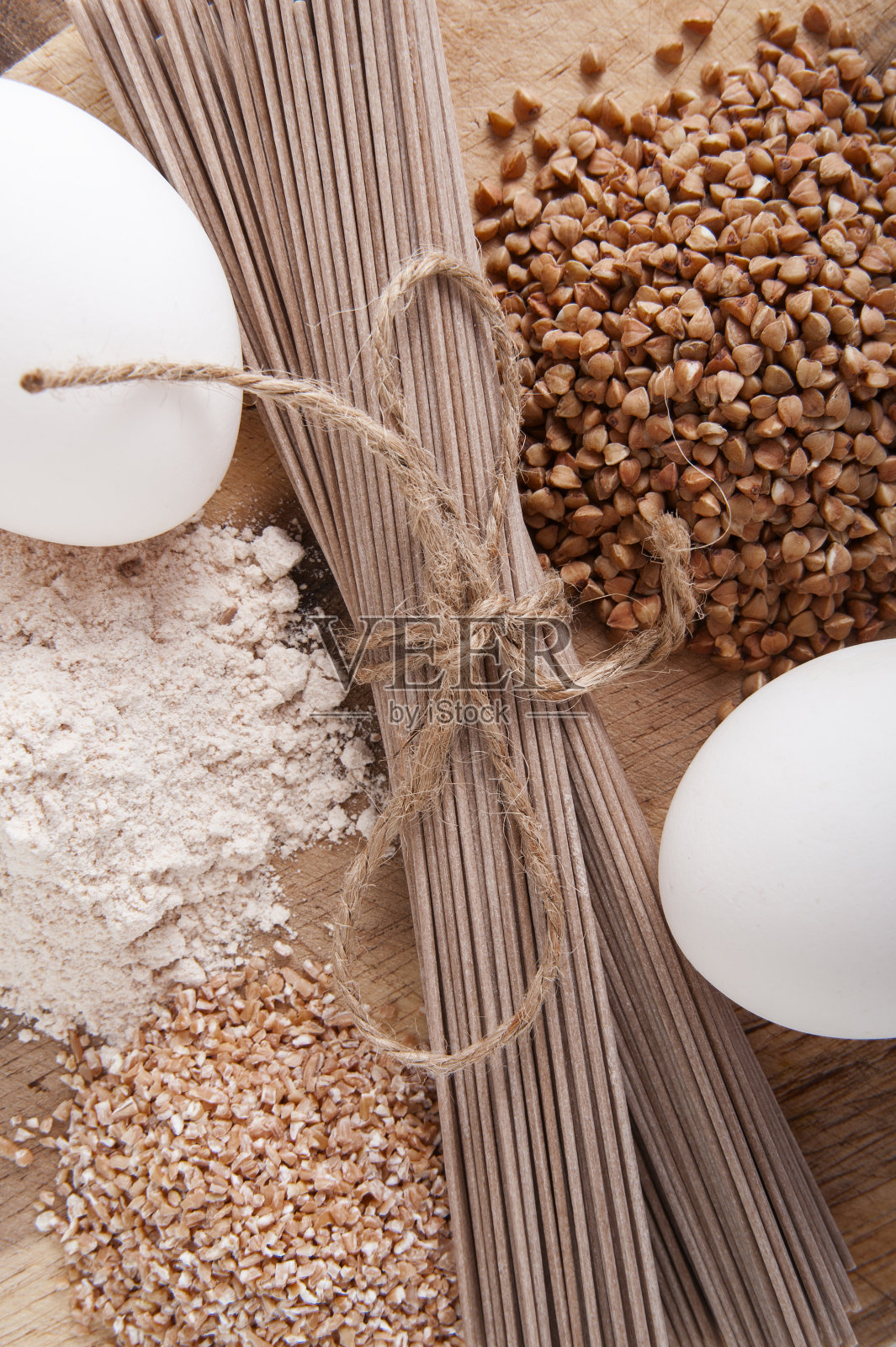 在木桌上用荞麦制成的产品:面条(荞麦),荞麦,面粉和谷物。照片摄影图片